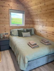 a bedroom with a bed in a log cabin at Caerlaverock Glamping - Sycamore in Dumfries +8 photos