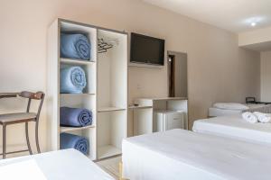 a hotel room with two beds and a tv at Hotel Conexão in Penha