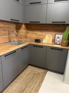 a kitchen with white cabinets and a sink and a rug at Apartment N 1 in Chernomorets