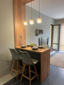 a kitchen with a island with chairs and lights at Apartment N 1 in Chernomorets