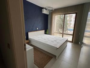 a bedroom with a bed in a room with a window at Apartment N 1 in Chernomorets