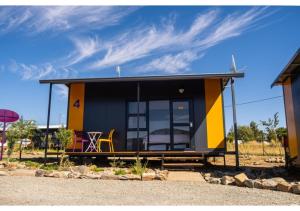 a tiny house with a yellow and blue exterior at SleepOver Colesberg in Colesberg