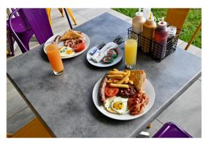 two plates of breakfast food on a table with orange juice at SleepOver Colesberg in Colesberg