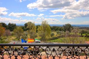 a balcony with a view of a park with flags at Hotel Rural Hojaranzos in Tejeda de Tiétar