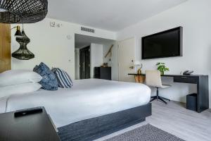a bedroom with a bed and a desk and a television at Angler's Hotel - Miami Beach in Miami Beach