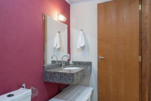 a bathroom with a sink and a pink wall at Hotel Conexão in Penha