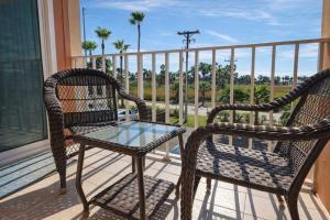 two wicker chairs and a glass table on a balcony at Beach Access Condo with Pool, Hot Tub Area & BBQ - Gulfview I - unit 213 in South Padre Island