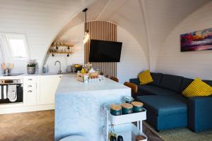 a living room with a blue couch and a kitchen at Pheasant Lodge in Little Bytham