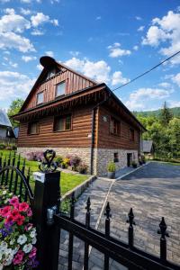 a wooden house with a fence in front of it at Rioba Chalet in Nová Bystrica