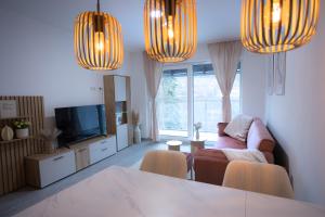 a living room with a couch and a television and lights at Signature Suites Sauerland in Winterberg