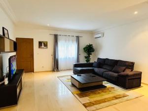a living room with a couch and a tv at Alima in Malabo