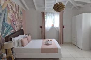 a bedroom with a large bed and a window at Villa Lawrencia, meublé de tourisme 4 étoiles in Morne-à-lʼEau
