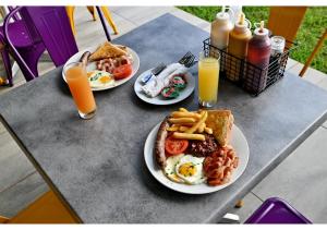 two plates of breakfast food on a table with orange juice at SleepOver Colesberg in Colesberg +11 photos