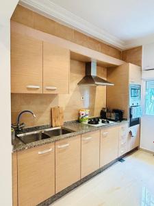 a kitchen with wooden cabinets and a sink at Alima in Malabo