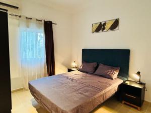 a bedroom with a large bed and a window at Alima in Malabo