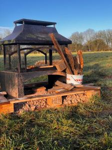 a pile of wood sitting on the grass at Happy Meadows - The Chick Inn in Long Stratton