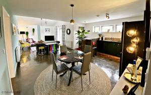 a dining room and living room with a table and chairs at Byre 2 In The Park in Callander