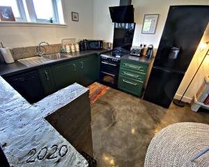 a kitchen with green cabinets and a black refrigerator at Byre 2 In The Park in Callander +13 photos