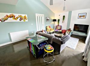 a living room with a couch and a table at Byre 2 In The Park in Callander