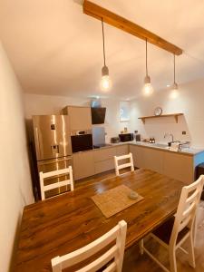 a kitchen and dining room with a wooden table and chairs at Brylach Steading in Aberlour
