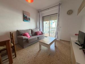a living room with a couch and a table at Wimpy Solo Familias Serviplaya in Playa de Xeraco