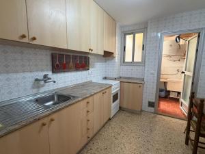 a kitchen with wooden cabinets and a sink at Wimpy Solo Familias Serviplaya in Playa de Xeraco
