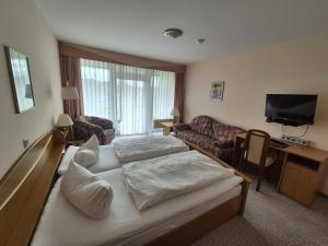 a hotel room with a bed and a couch at Hotel Hahnenkleer Hof in Hahnenklee-Bockswiese