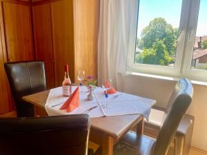 a table with two wine glasses and a window at Ride & Rest, Budget, Waschmaschine, Wohnzimmer, Küche, Radlgarage in Altötting +19 photos