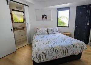 a bedroom with a large bed and a bathroom at Beach and Breeze in Mooloolaba +18 photos