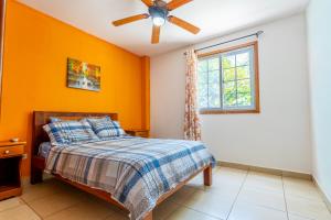 a bedroom with orange walls and a bed with a ceiling fan at Kevin Kondos in Bocas Town