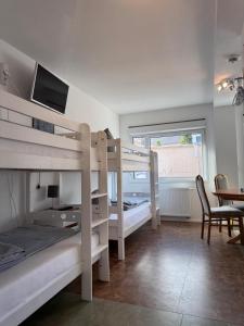 a bedroom with two bunk beds and a table at Motel Home Berlin in Berlin