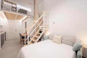 a bedroom with a white bed and a staircase at Baélia Experience Hotel boutique in Alicante
