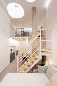a staircase in a living room next to a kitchen at Baélia Experience Hotel boutique in Alicante