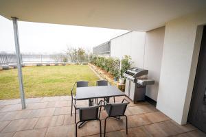 a patio with a table and chairs and a grill at RheinView Residence - Apartment in Mainz