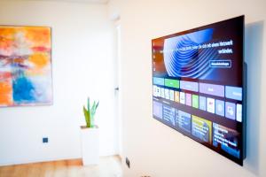 a flat screen tv hanging on a wall in a room at RheinView Residence - Apartment in Mainz