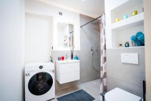 a bathroom with a washing machine and a sink at RheinView Residence - Apartment in Mainz +31 photos