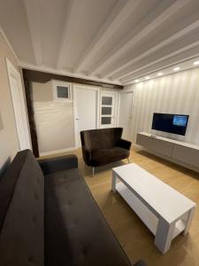 a living room with a couch and a tv at Apartamentos Castro Urdiales Centro con Parking in Castro-Urdiales