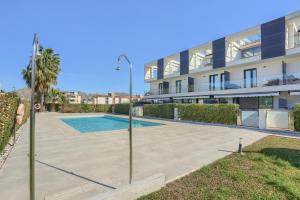 an apartment with a swimming pool in front of a building at La Perla 3 in El Port