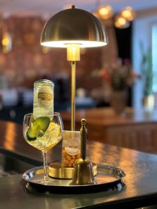a tray with a glass of wine and a lamp at Akademihotellet in Uppsala