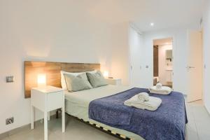 a bedroom with a large bed with towels on it at La Perla 3 in El Port +23 photos