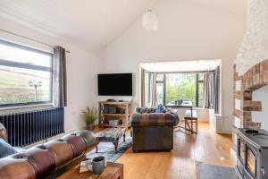 a living room with a couch and a television at 1 Bed in Croyde oc-forda in Croyde