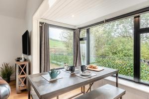 a living room with a table and a large window at 1 Bed in Croyde oc-forda in Croyde
