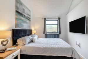 a bedroom with a bed and a flat screen tv at 1 Bed in Croyde oc-forda in Croyde +12 photos