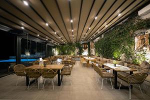 a restaurant with tables and chairs and a green wall at Evia Silence in Boufalo