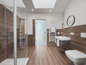 a bathroom with a toilet and a sink and a shower at NORA Turmhaus am Bergheider See in Buschmühle +11 photos