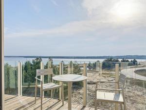 a table and two chairs on a deck with a view of the water at NORA Turmhaus am Bergheider See in Buschmühle