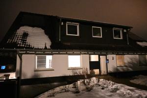 a black and white house in the snow at night at Signature Suites Sauerland in Winterberg