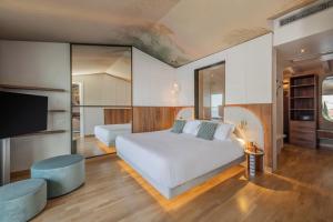 a bedroom with a bed and a flat screen tv at Hotel Val Di Sogno - Adults Only in Malcesine +62 photos