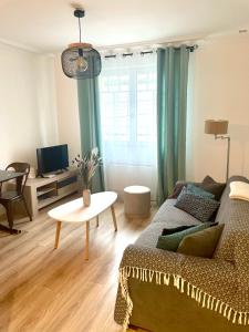 a living room with a couch and a table at L'Opale in Wimereux