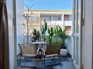 a balcony with two chairs and a table and plants at Chu homestay in Thôn Trường Giang